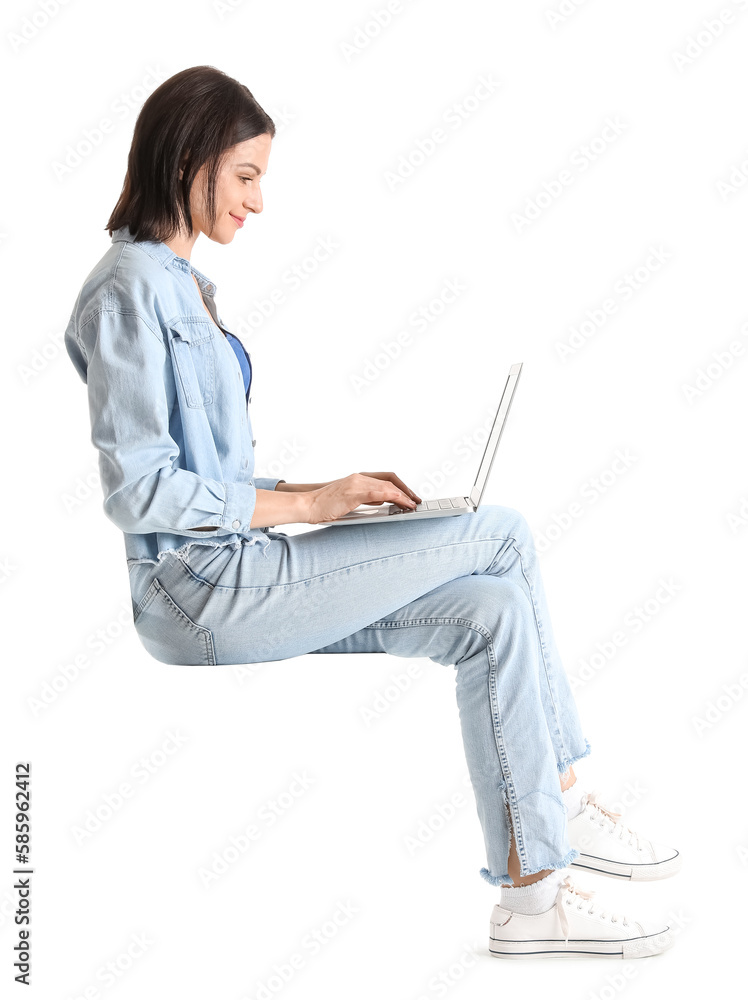 Pretty young woman with laptop sitting on chair against white background