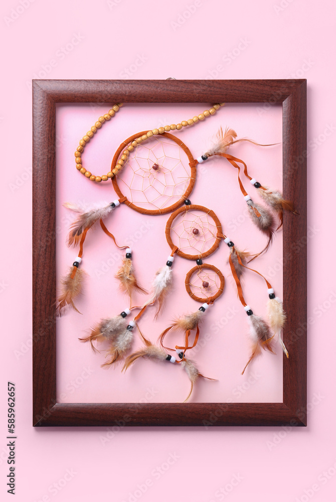 Frame with beautiful dreamcatcher on pink background