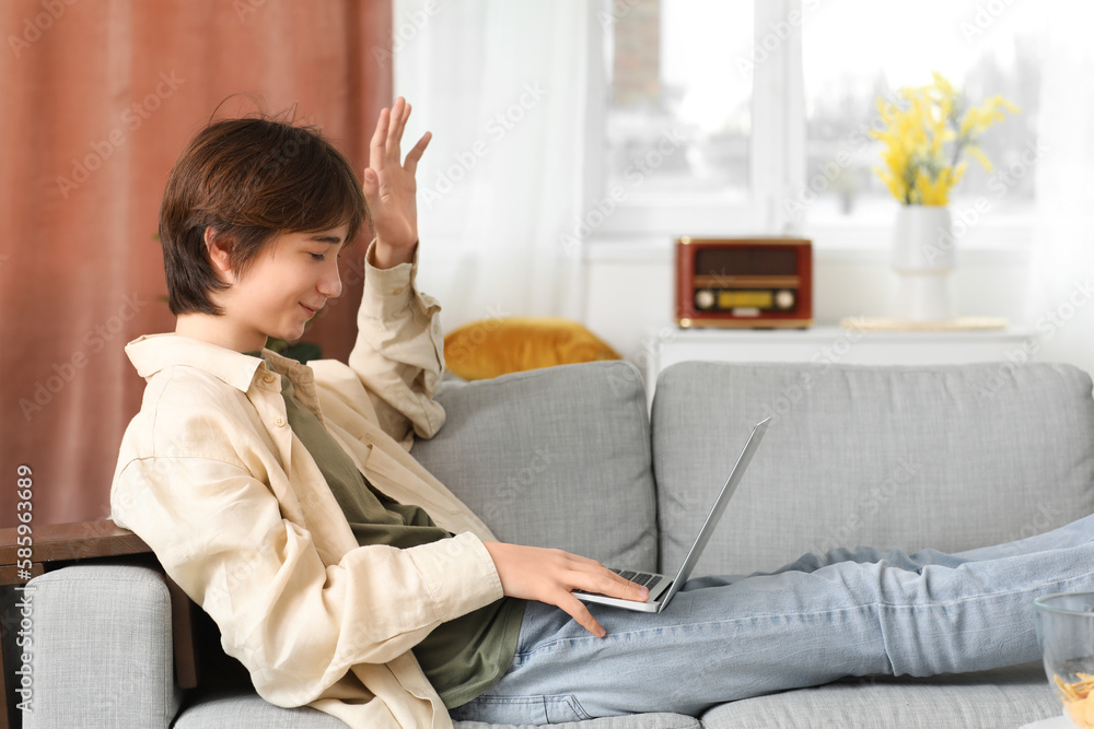 Male student with laptop studying online at home