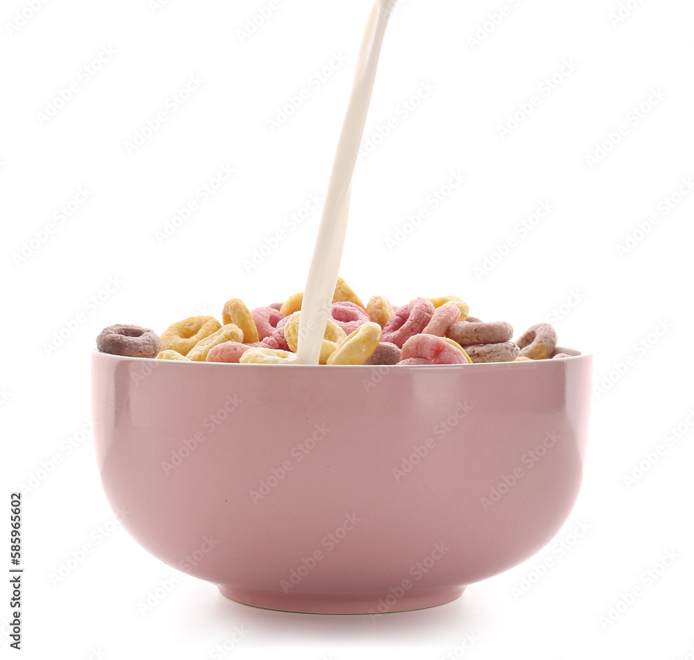 Pouring of milk into bowl with colorful cereal rings isolated on white background