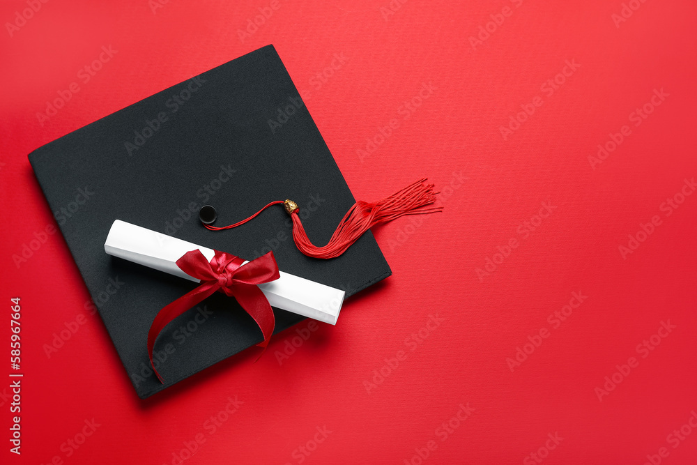 Diploma with ribbon and graduation hat on red background