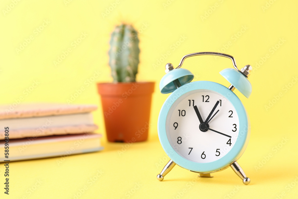 Vintage alarm clock on yellow background