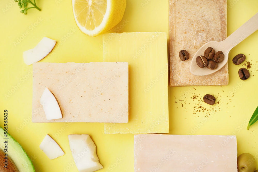 Composition with soap bars and natural ingredients on yellow background