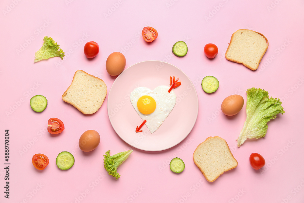 Plate with cute childrens breakfast, eggs, vegetables and bread on pink background