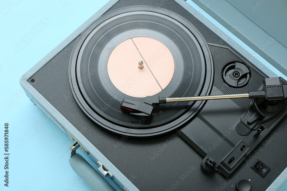 Record player with vinyl disk on blue background, closeup