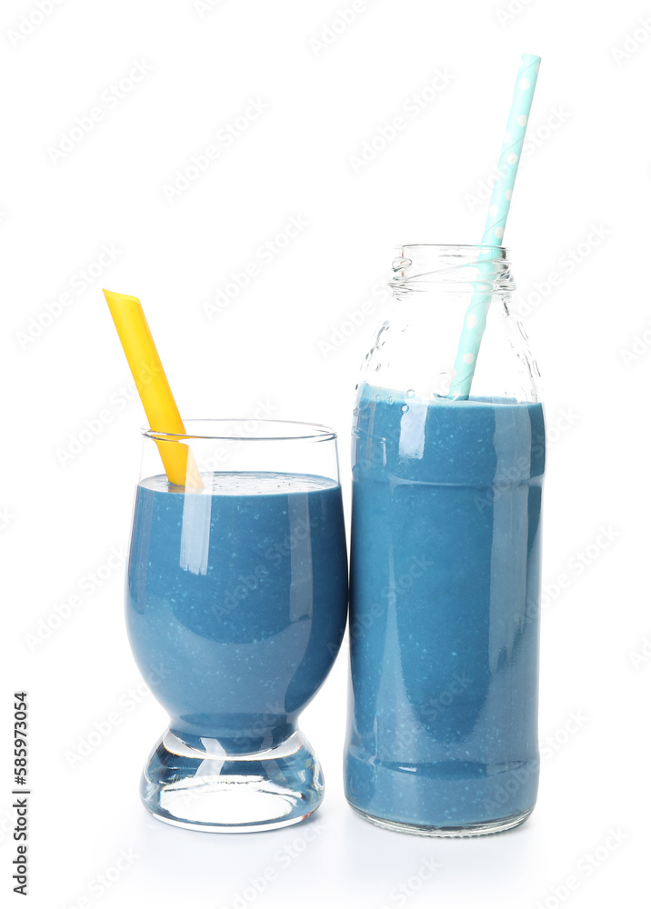 Glass and bottle of tasty blue smoothie with straws on white background