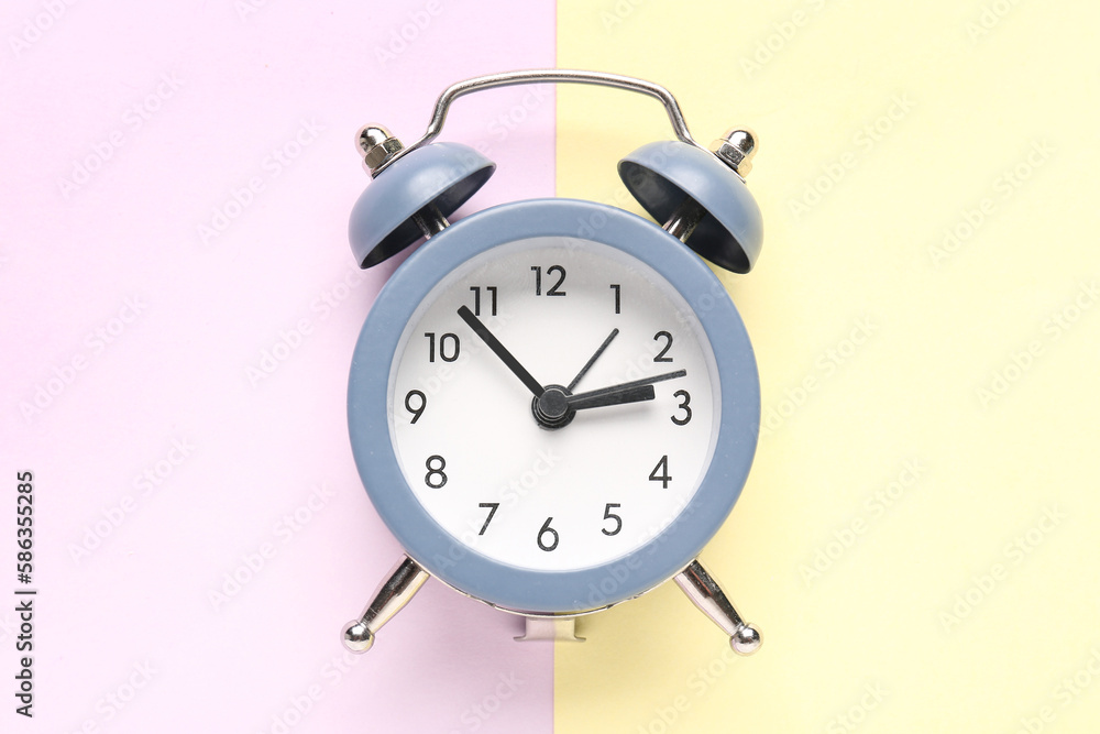 Vintage alarm clock on color background