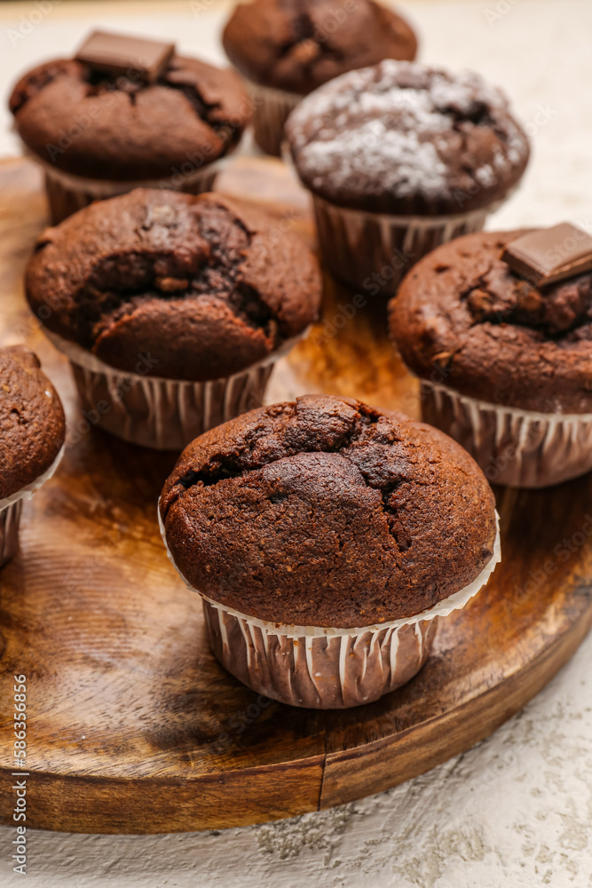 plate with tasty chocolate cupcakes on light background, closeup