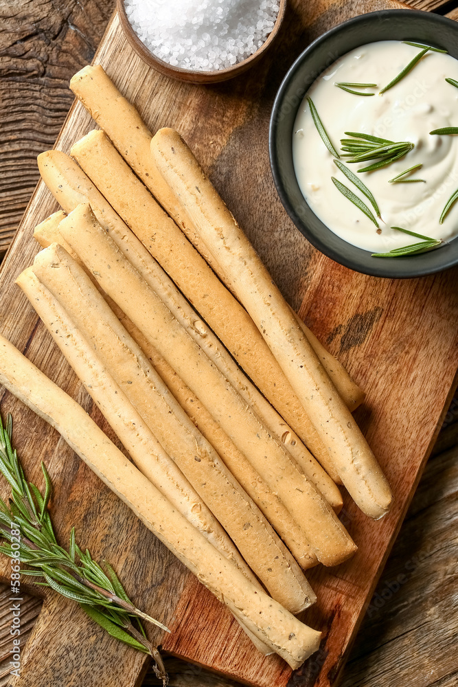 Board with tasty Italian Grissini on wooden background