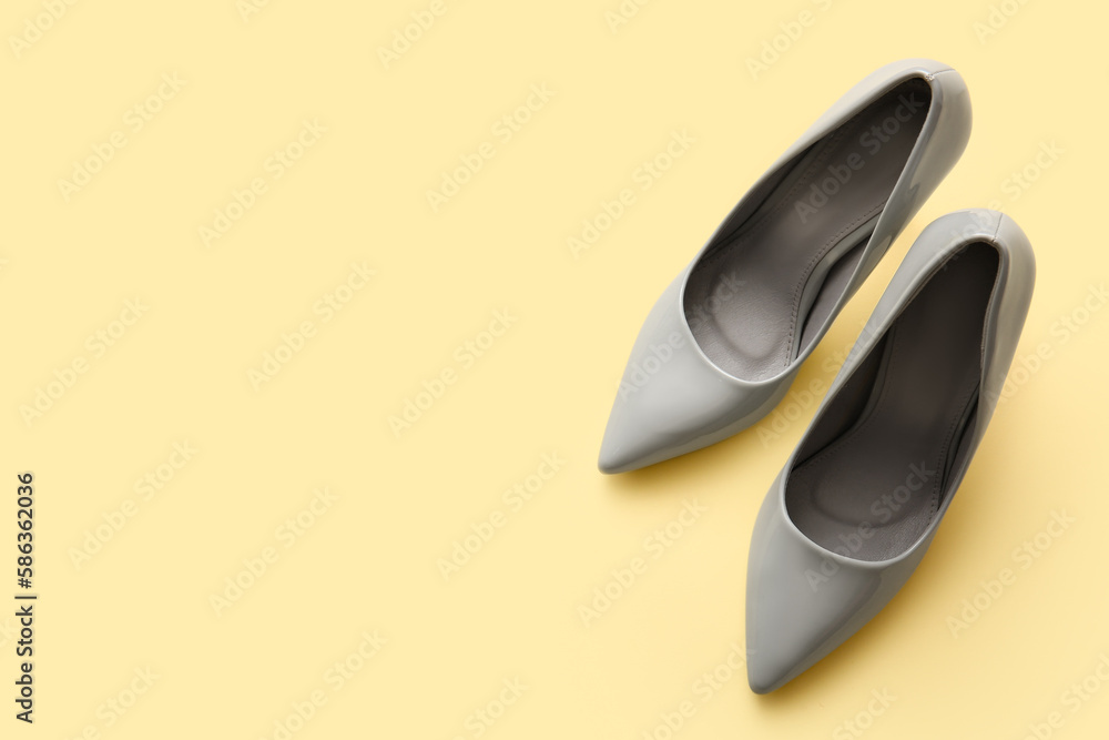 Stylish high heeled shoes on beige background