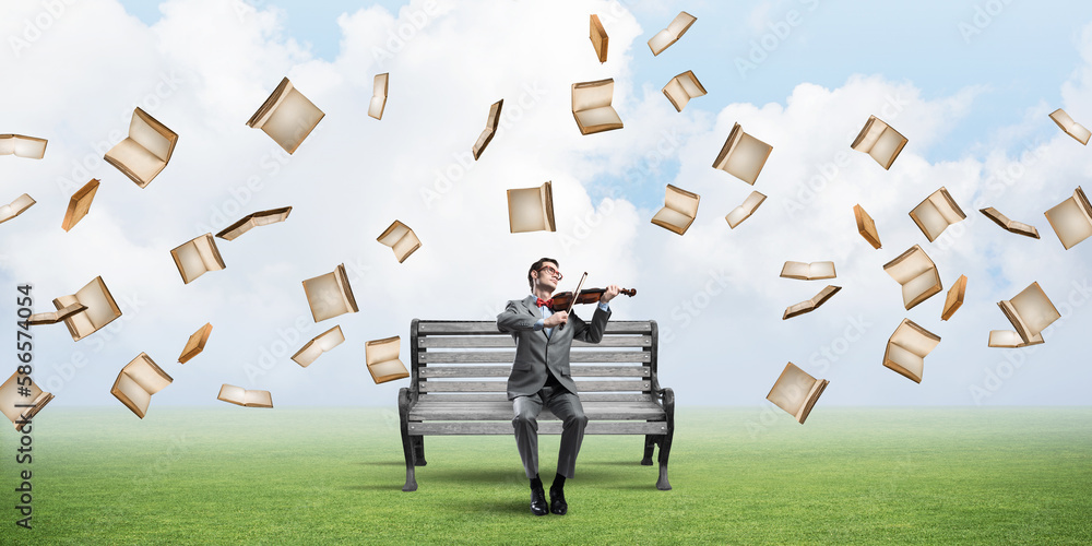 Handsome businessman in park on wooden bench play his melody