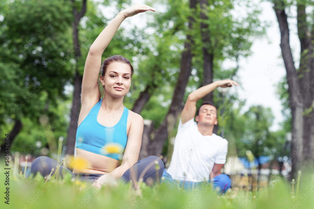 Couple of young sporty people practicing yoga