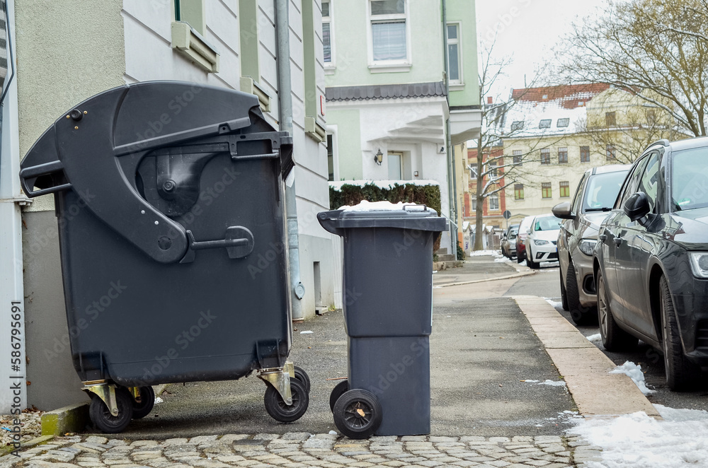 View of garbage containers in city on winter day