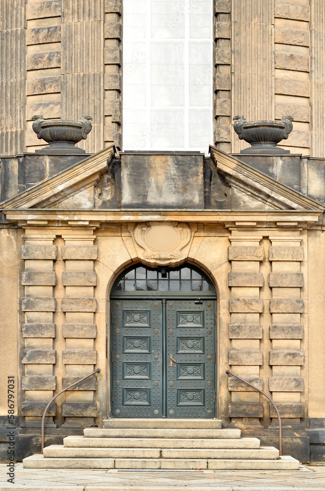 View of old building with wooden door and steps