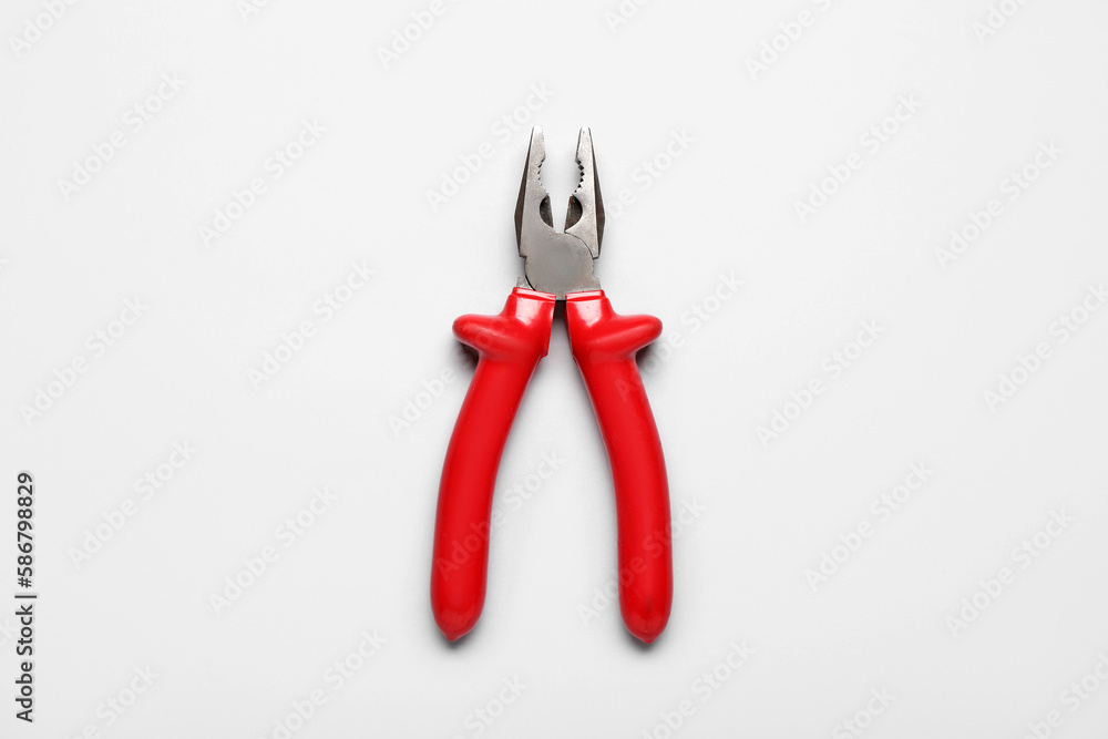 Red pliers on grey background