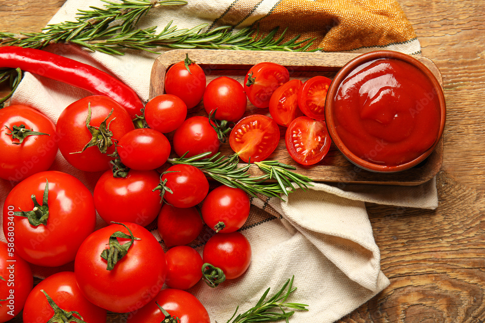 Bowl with tasty ketchup and fresh vegetables on wooden background