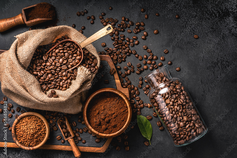 Scoop of coffee beans in a bag on dark background. Top view of coffee in a cup. Copy space for text