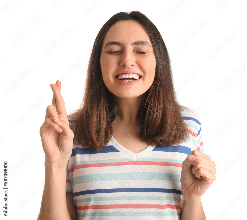 Young woman crossing fingers on white background