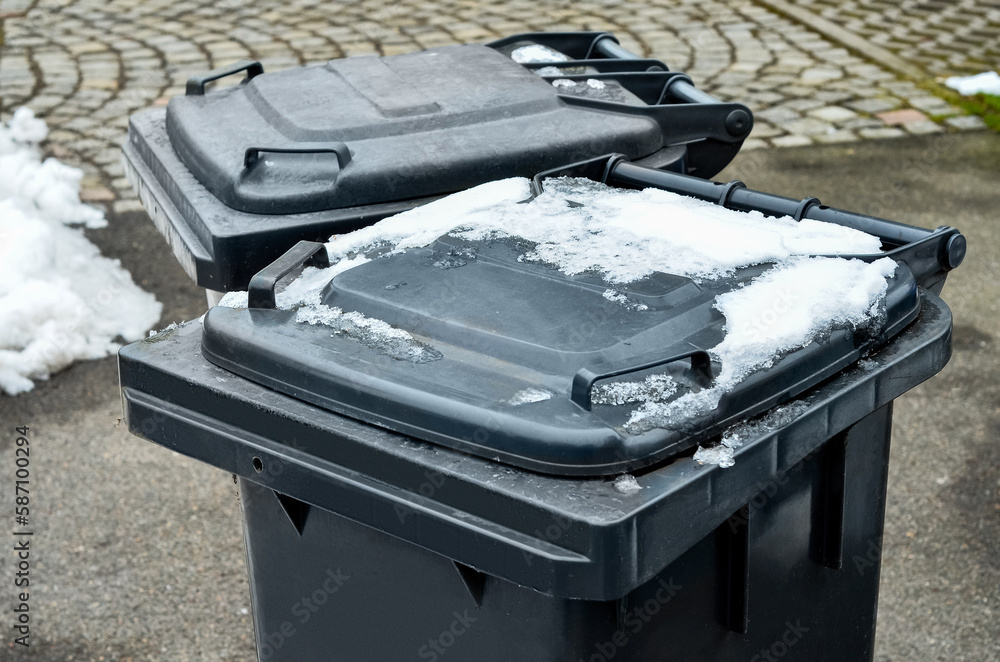 View of garbage containers in city on winter day, closeup