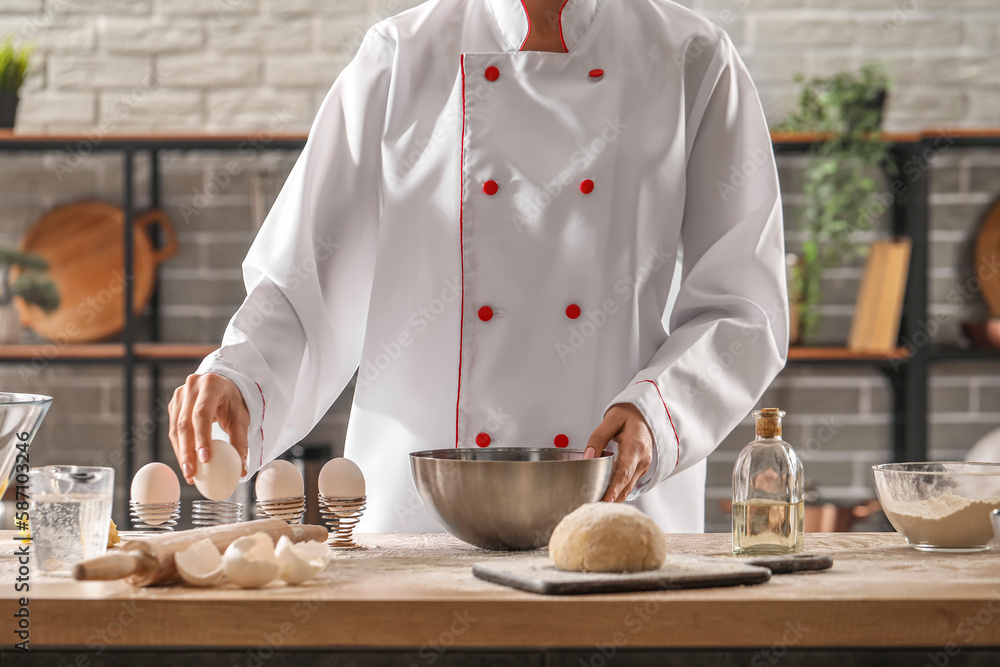 Female chef making dough for pasta at table in kitchen, closeup