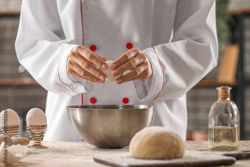 Female chef making dough for pasta at table in kitchen, closeup