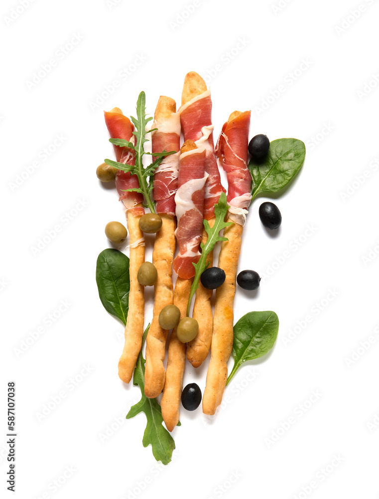 Tasty Italian Grissini with bacon, olives and spinach leaves on white background