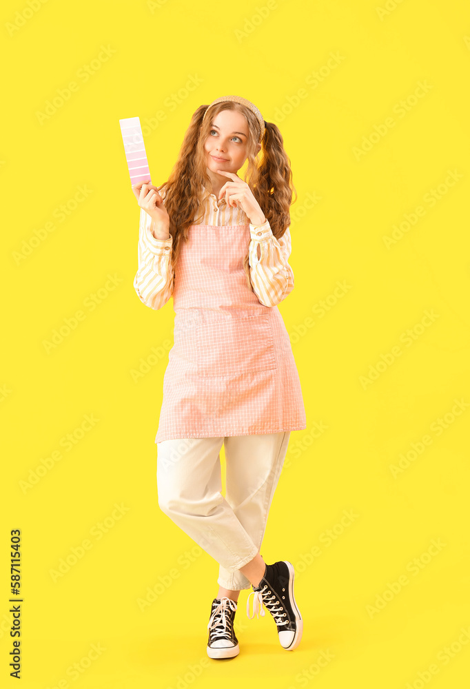 Thoughtful female artist with paint color palette on yellow background