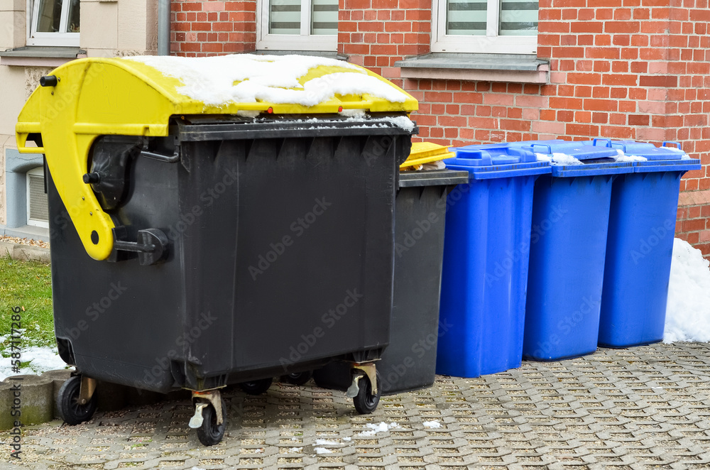 View of garbage containers in city on winter day