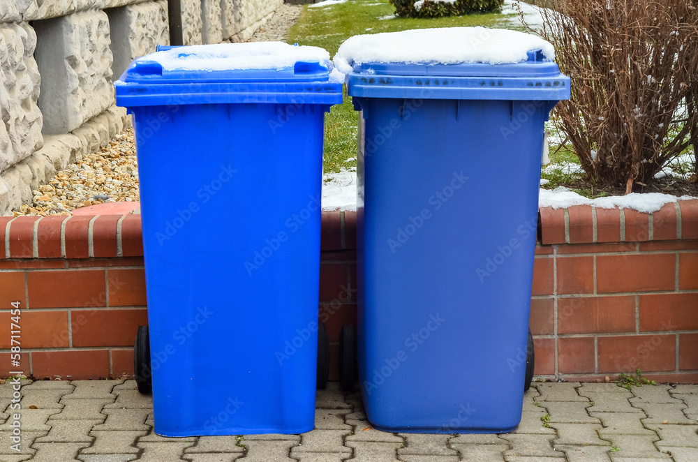 View of garbage containers in city on winter day