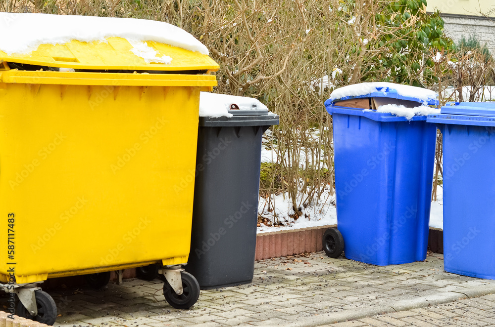 View of garbage containers in city on winter day