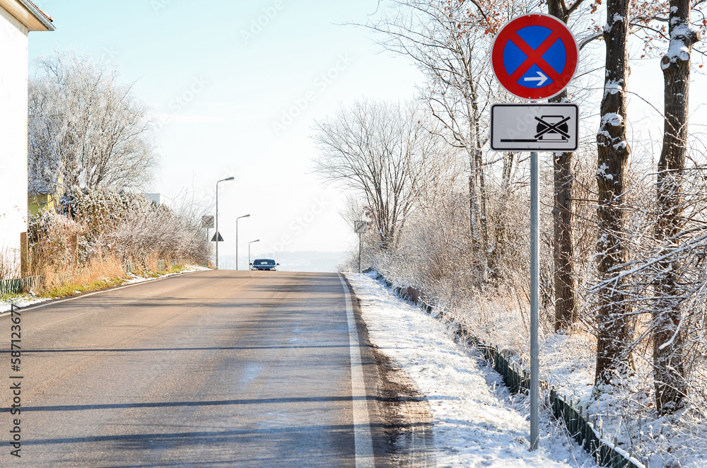 View of city street with NO PARKING sign on winter day