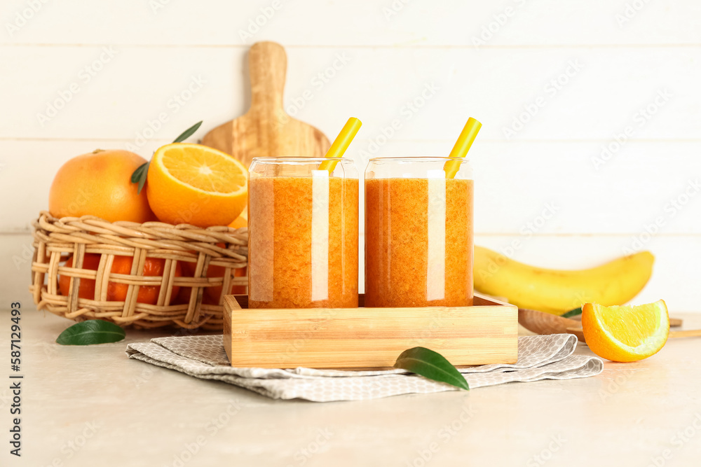 Glasses of healthy smoothie and fresh fruits on light background