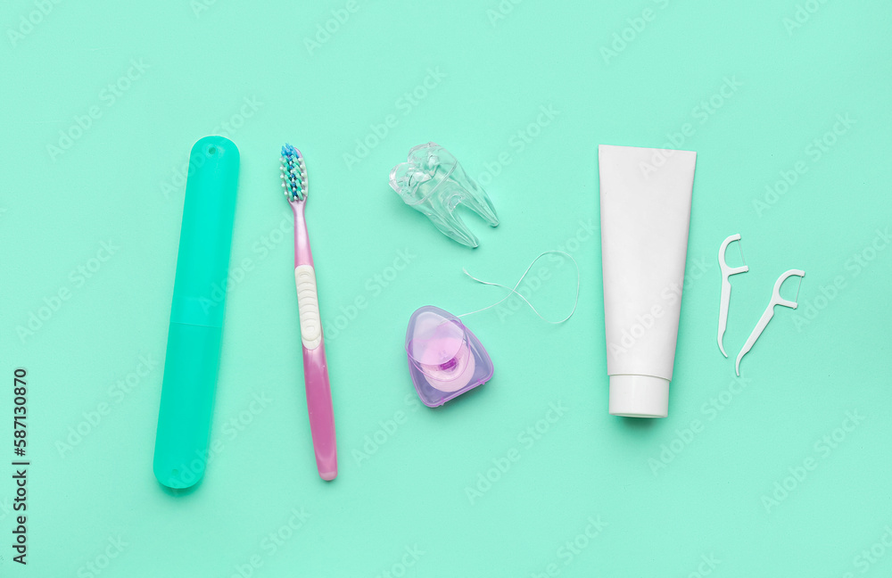 Set for oral hygiene and plastic tooth model on turquoise background