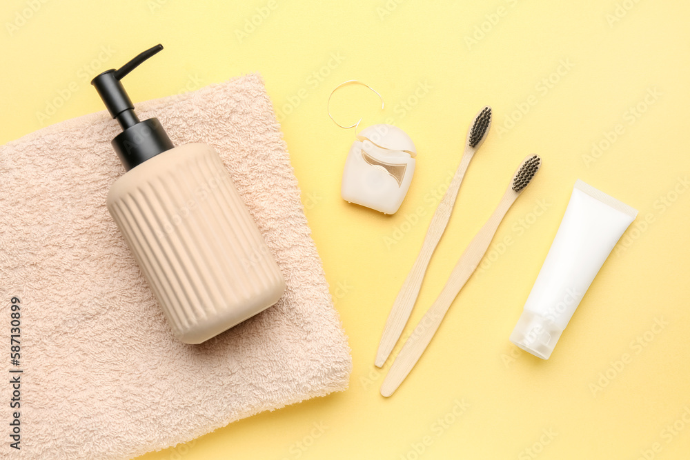 Dental floss and bath accessories on yellow background