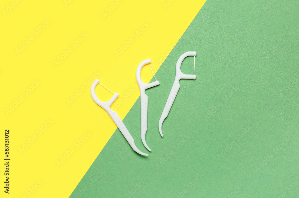 Floss toothpicks on yellow and green background