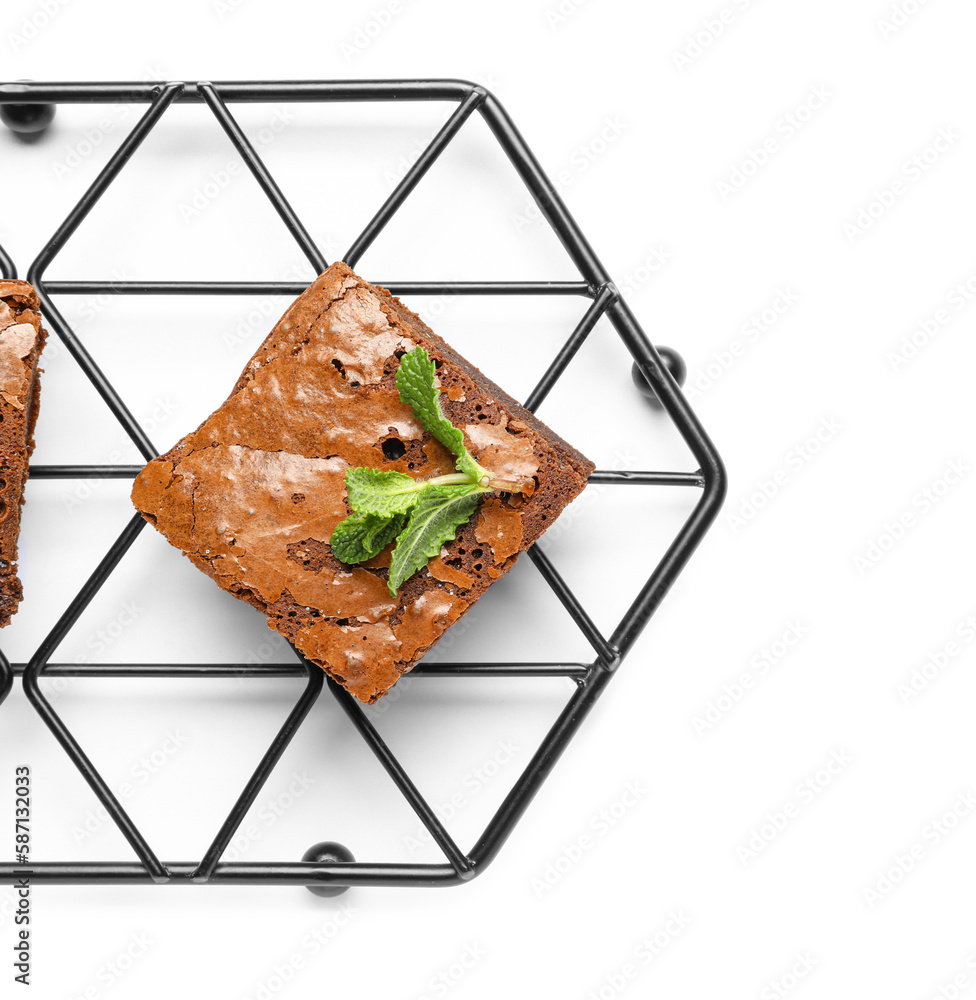 Grid with piece of tasty chocolate brownie isolated on white background, closeup