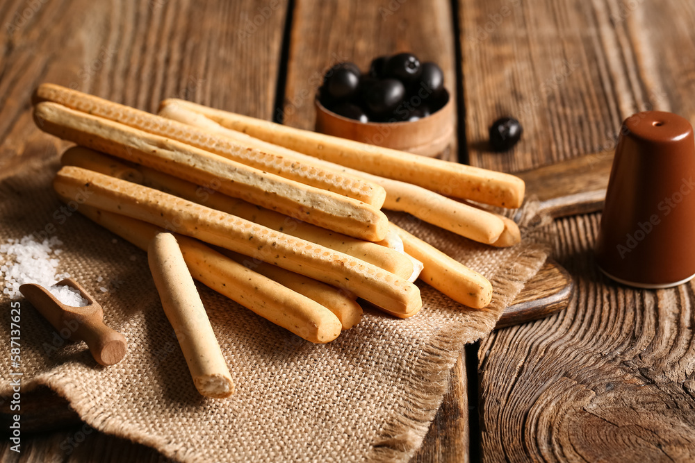 Board with tasty Italian Grissini on wooden background