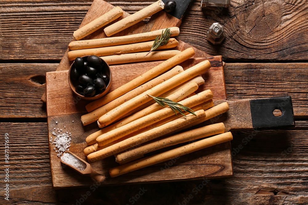 Board with tasty Italian Grissini on wooden background