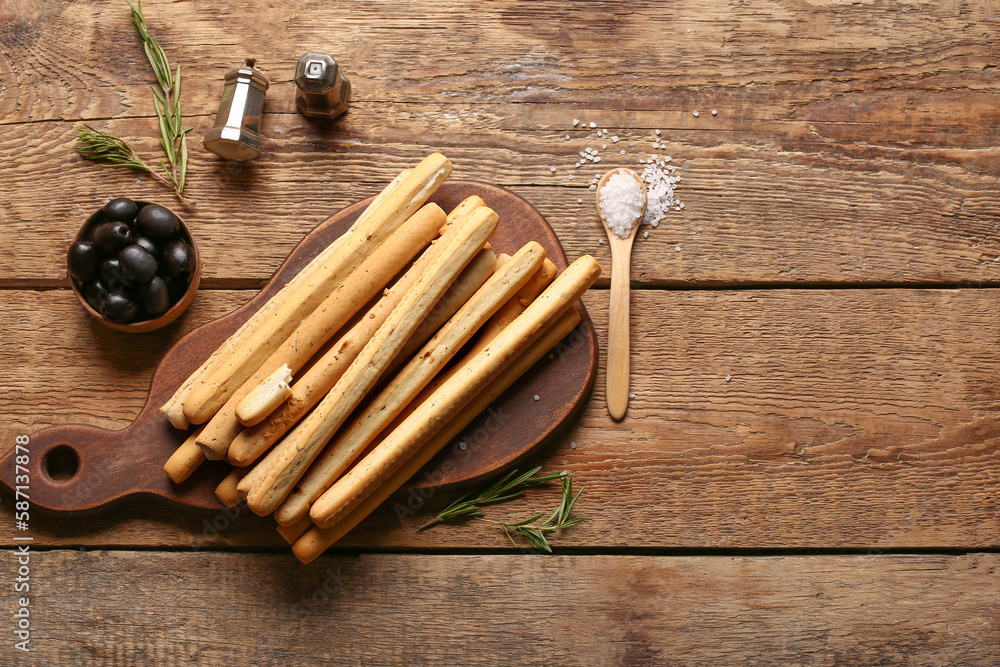 Board with tasty Italian Grissini on wooden background