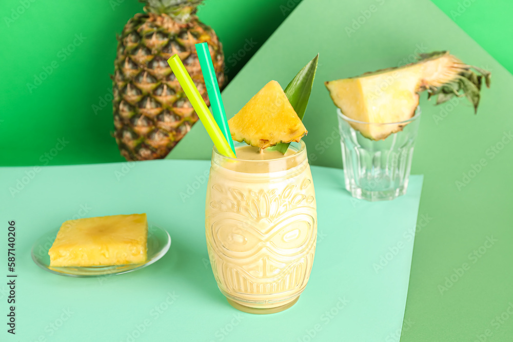 Glass of tasty pineapple smoothie with straws on color background