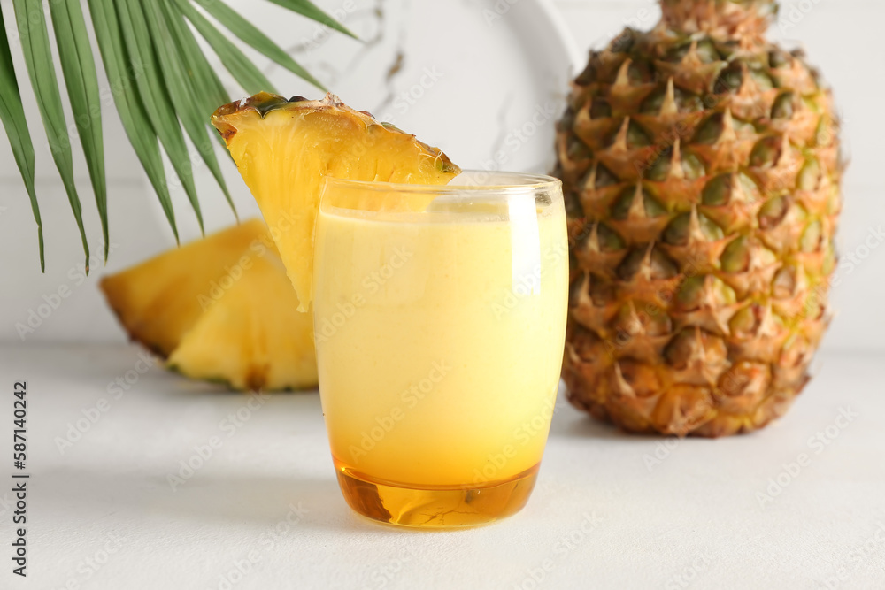 Glass of tasty pineapple smoothie on table