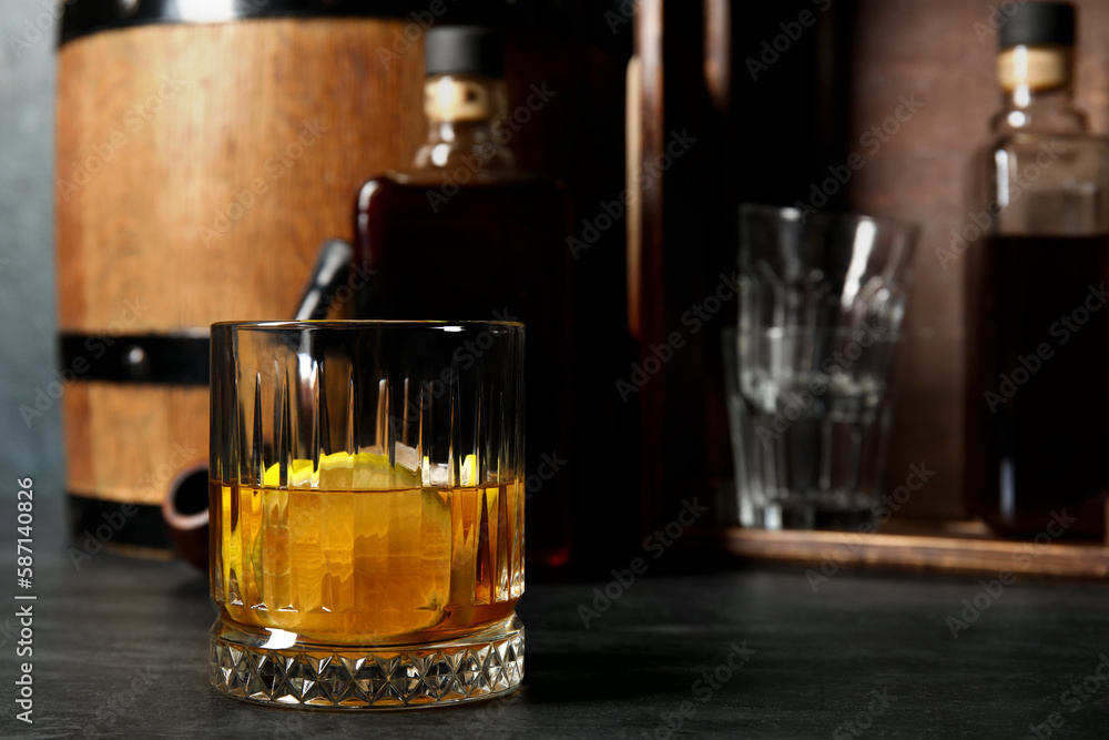 Glass of cold rum on dark background