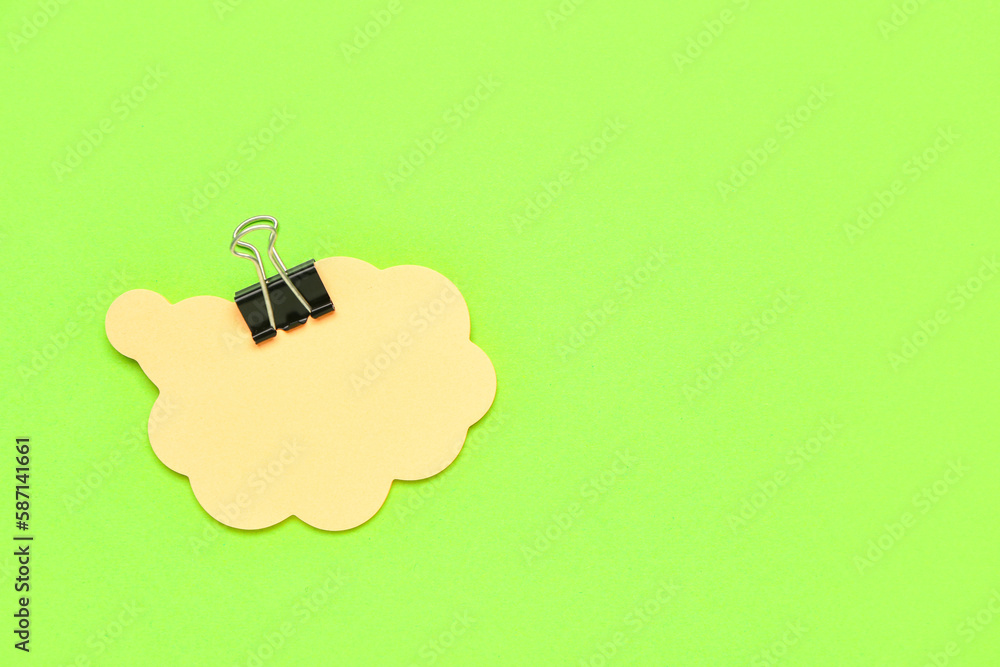 Composition with sticky notes and paperclip on green background