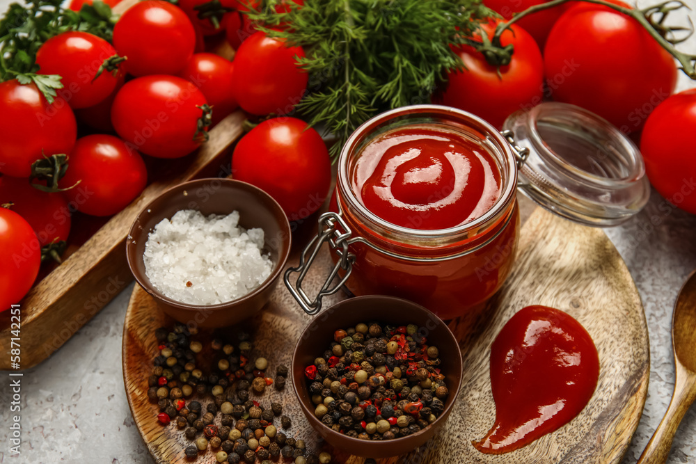 Jar with tasty ketchup and fresh vegetables on table, closeup