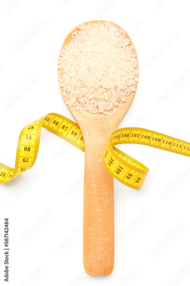 Wooden spoon with rice and yellow measuring tape on white background. Diet concept