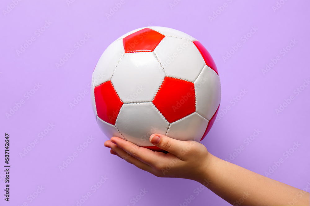 Hand with soccer ball on lilac background