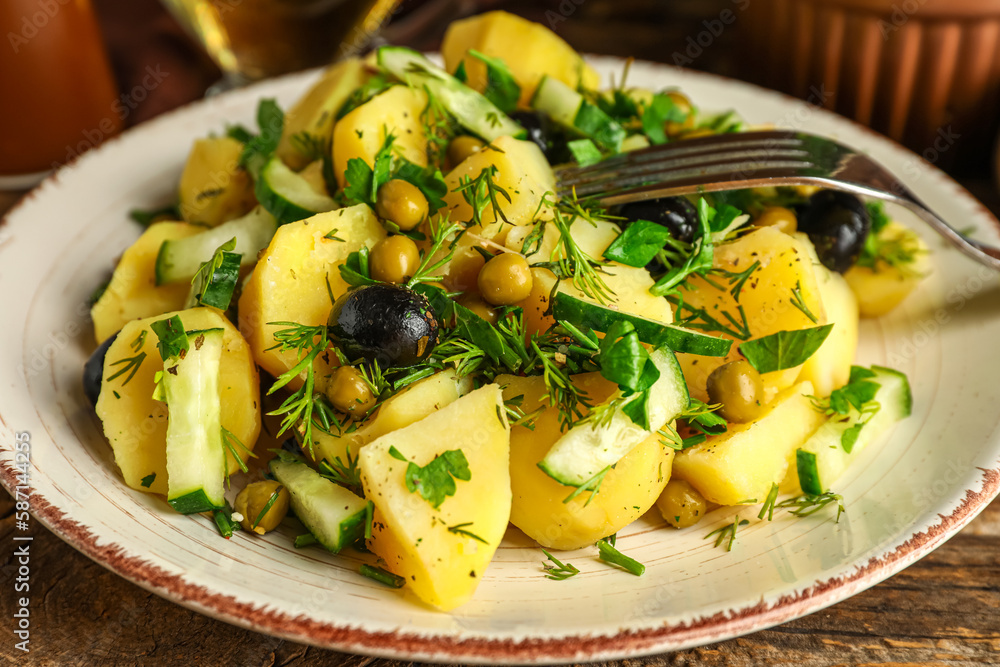 Plate of tasty Potato Salad with vegetables on table, closeup