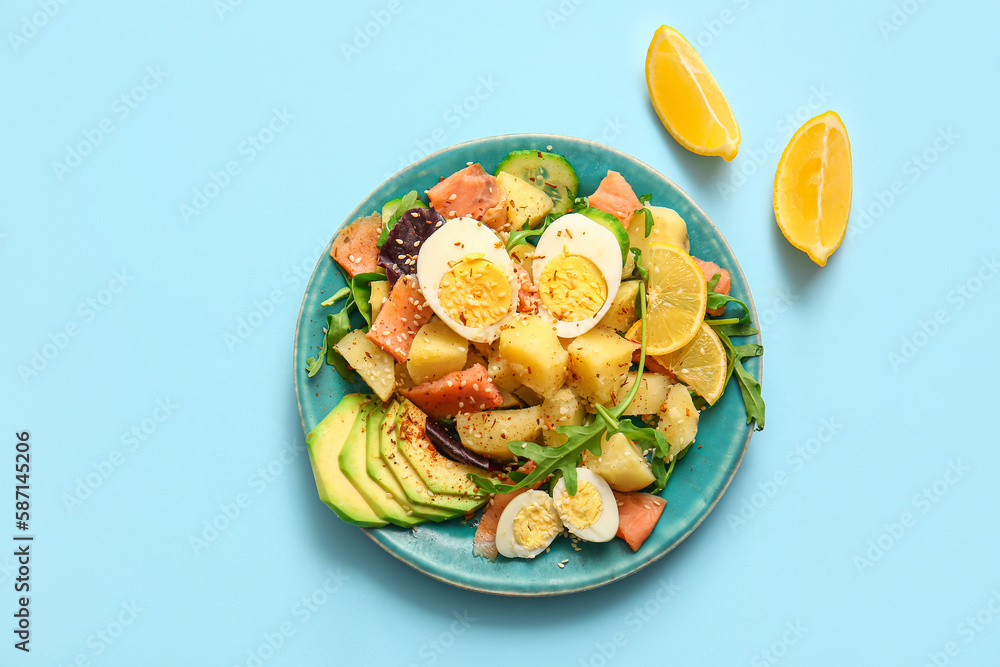 Plate of tasty potato salad with eggs and avocado on light blue background, top view