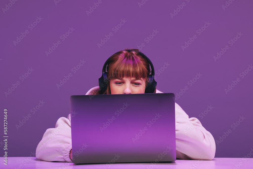 Woman playing an online video game on her laptop