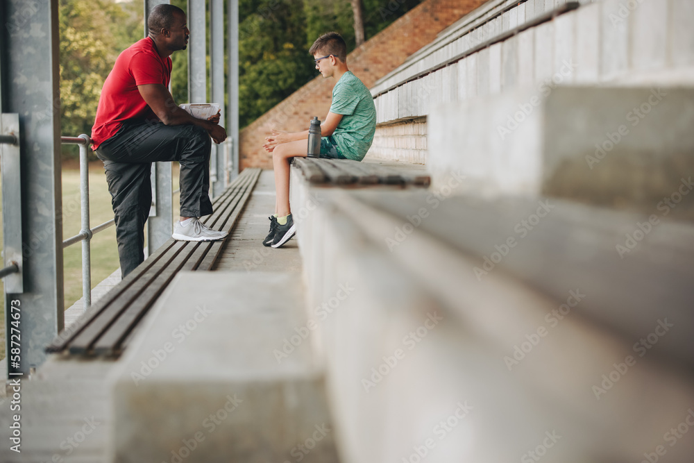 Coach motivating a sad school kid outdoors